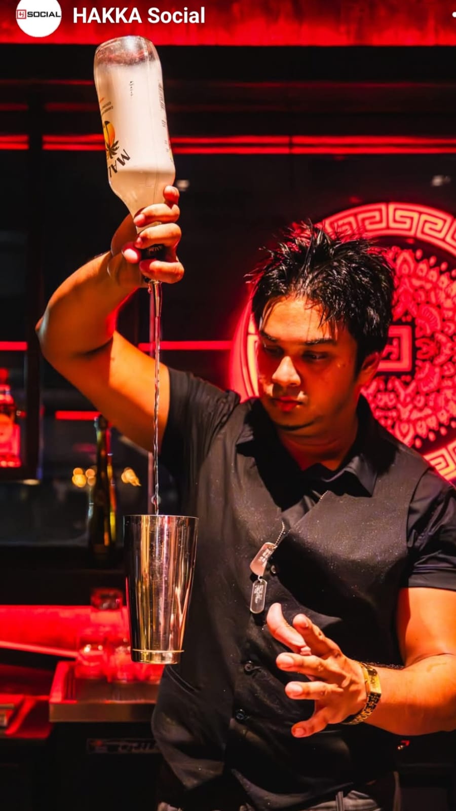 Saied Ali pouring a precision stream behind the bar at HAKKA Social